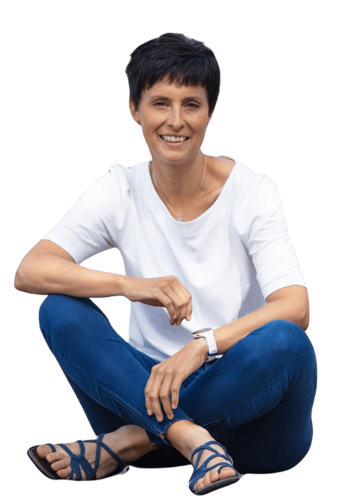 uniquewebdesigns - Kerstin Butz sitzt im Schneidersitz und lächelt – Webdesignerin für empathische Webseiten